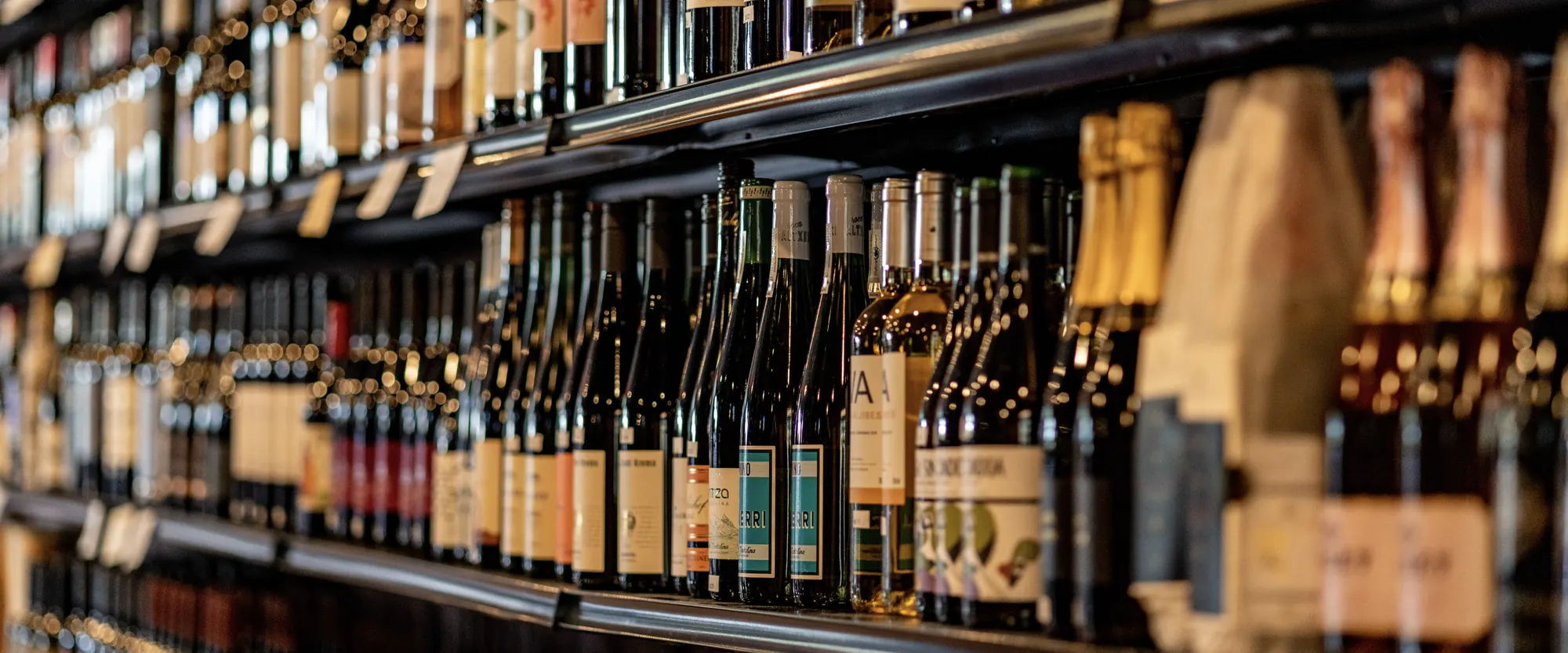 Rows of Spanish and Portuguese wine on the shelves at La Vid, sparkling bottles in the foreground