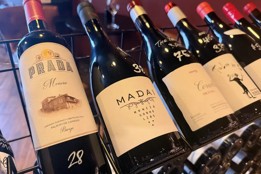 Bierzo bottles in a rack at La Vid: Prada Mencía, Madai, and Corullón, each with a handwritten price