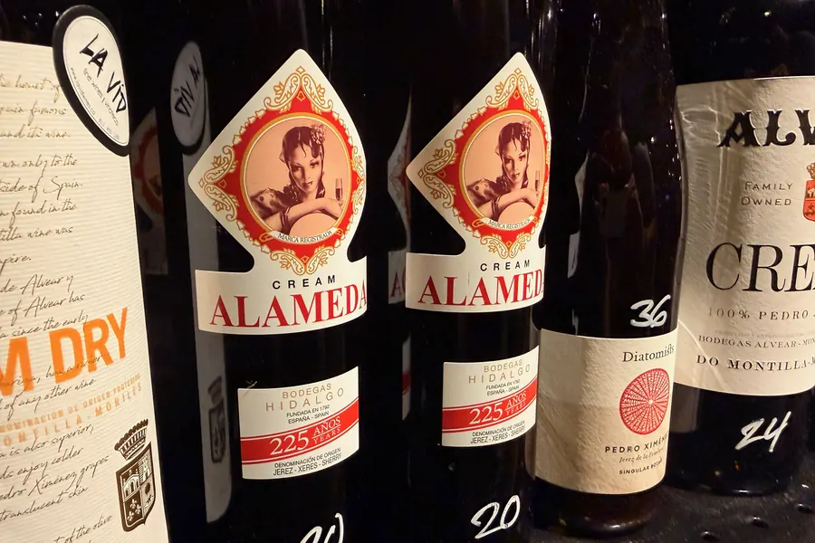 La Vid’s sherry shelf: bottles of Alameda Cream, a dry sherry, and Alvear, each with a handwritten price